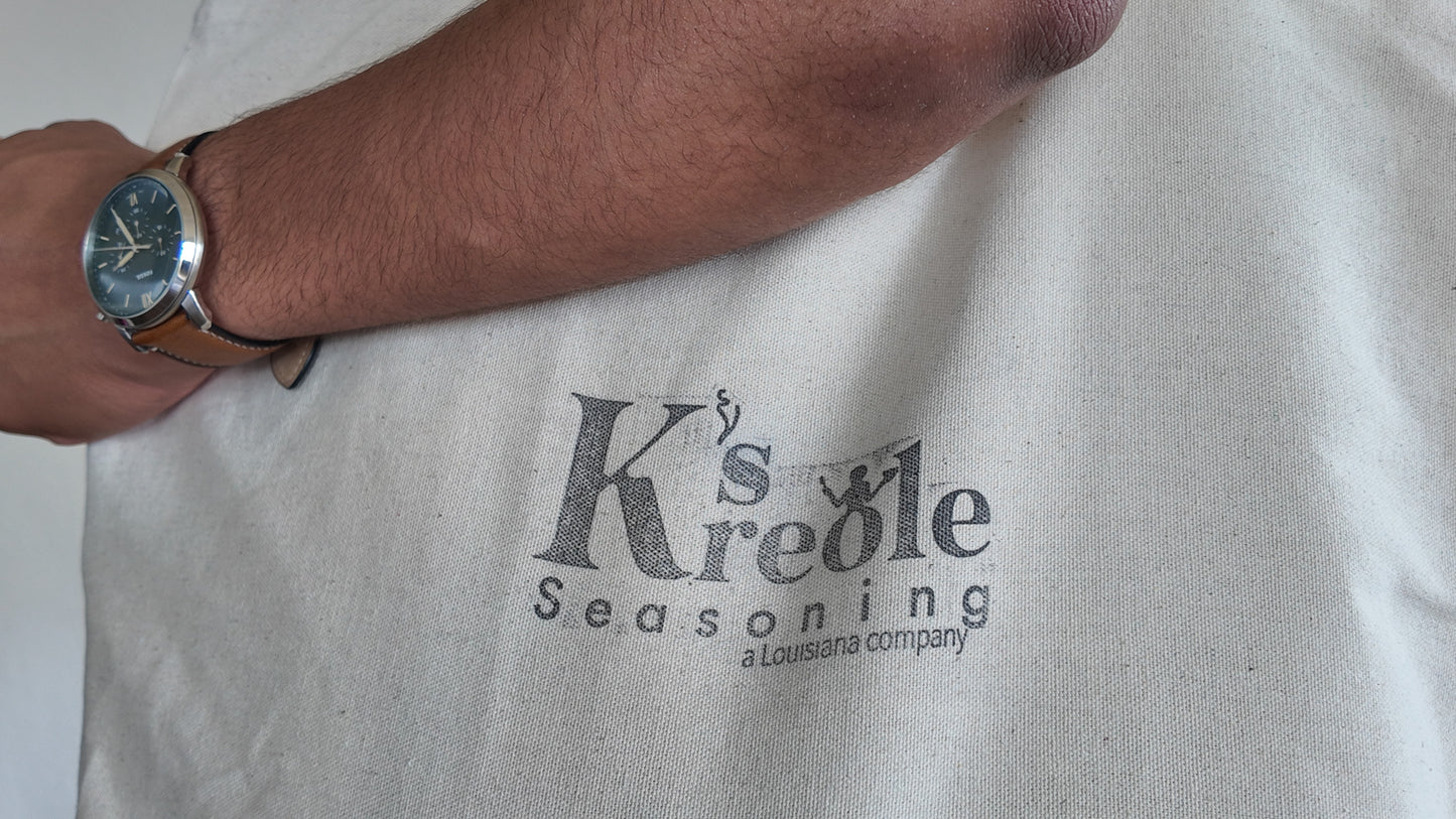 Person holding cotton reusable grocery tote with K's Kreole Seasoning label