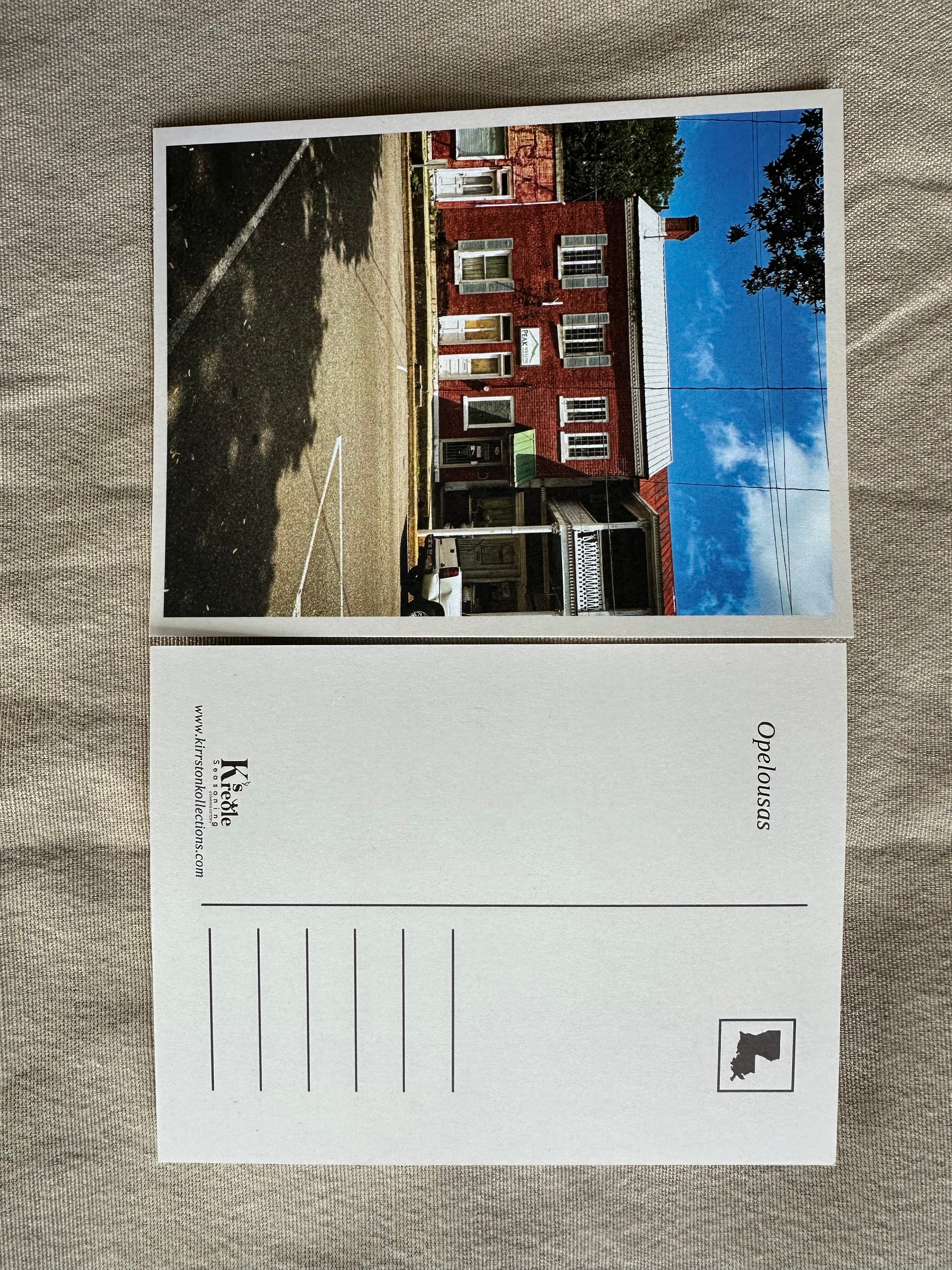 Postcard with a printed image of a building on a textured surface
