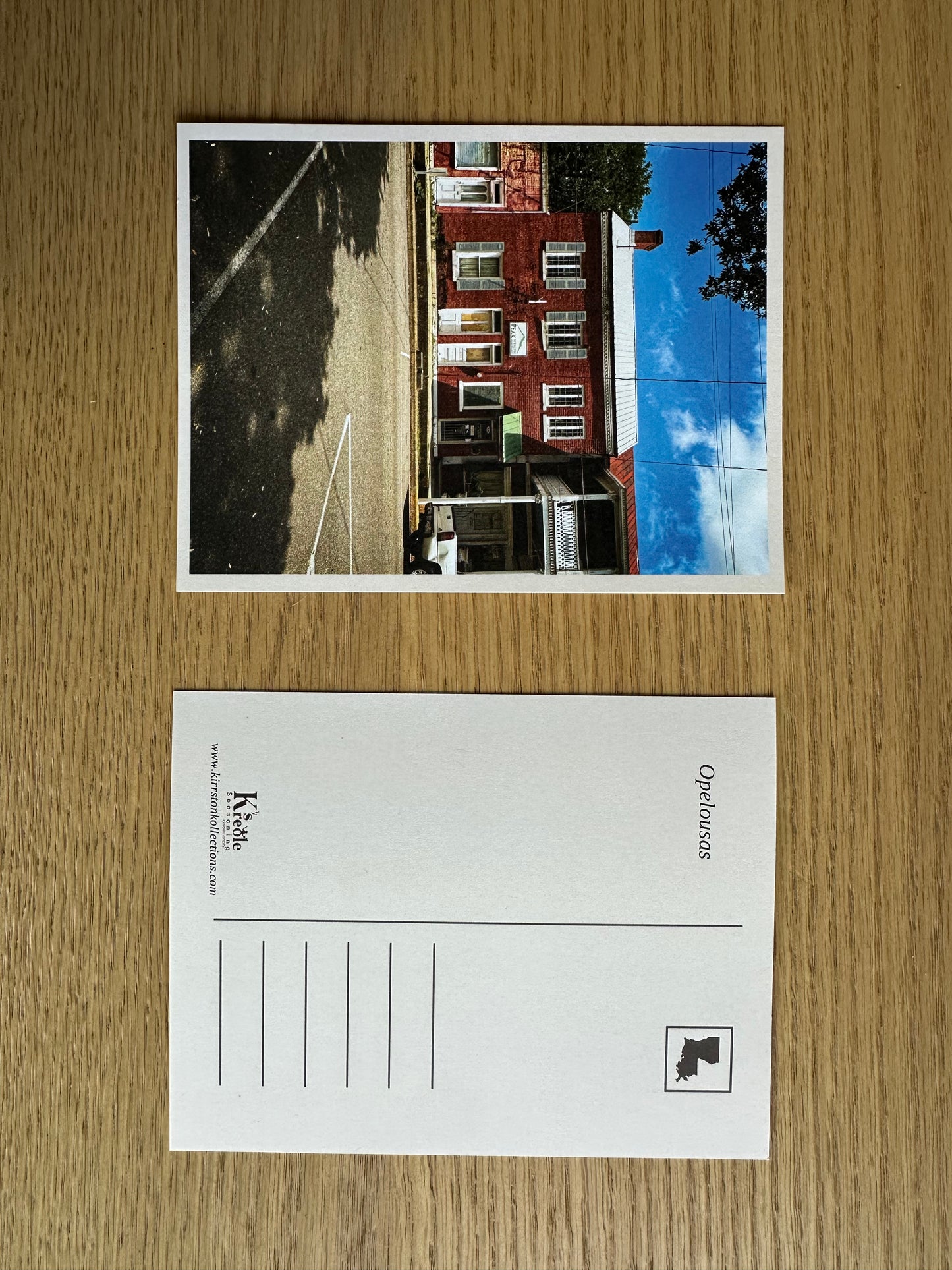 Postcard with a printed image of a house on a wooden surface